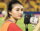 Nguyệt Hà cầm máy ảnh bên sân bóng